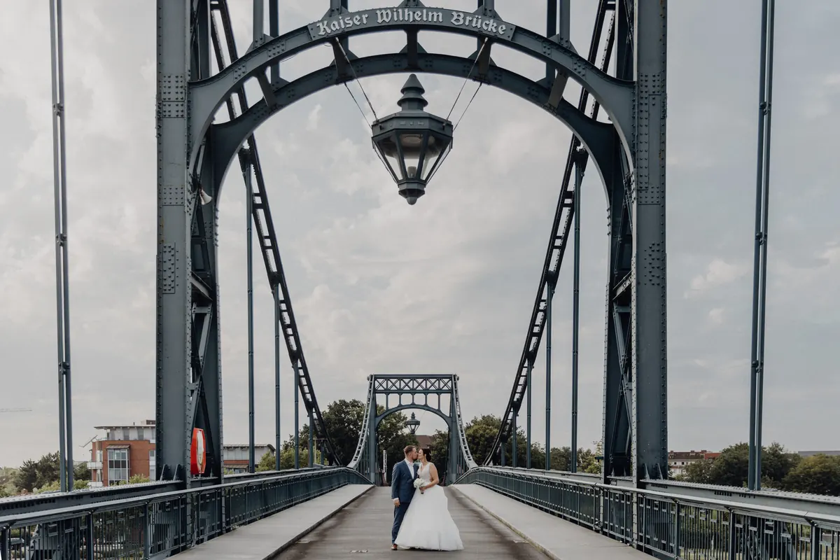 Brautpaar auf einer Brücke am Wasser